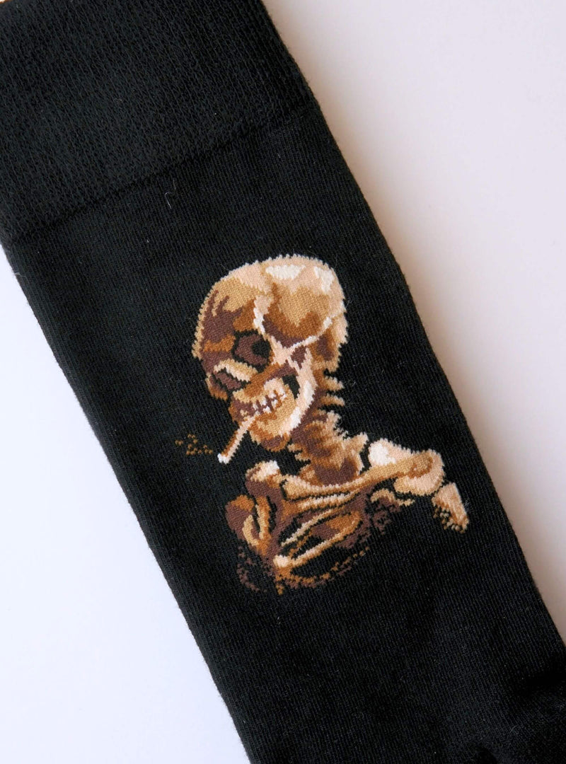 Schädel eines Skeletts mit brennender Zigarette